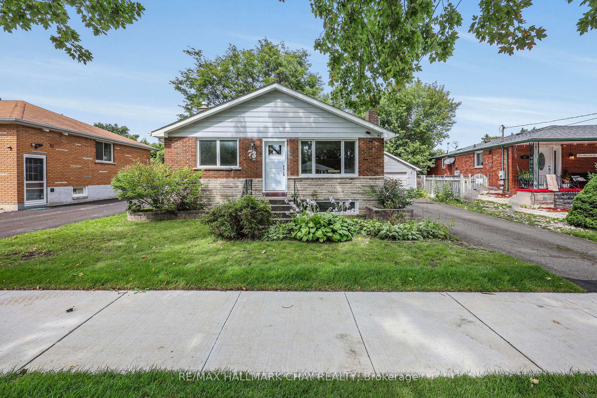 Brick bungalow with a white gabled roof, landscaped front garden, and driveway.