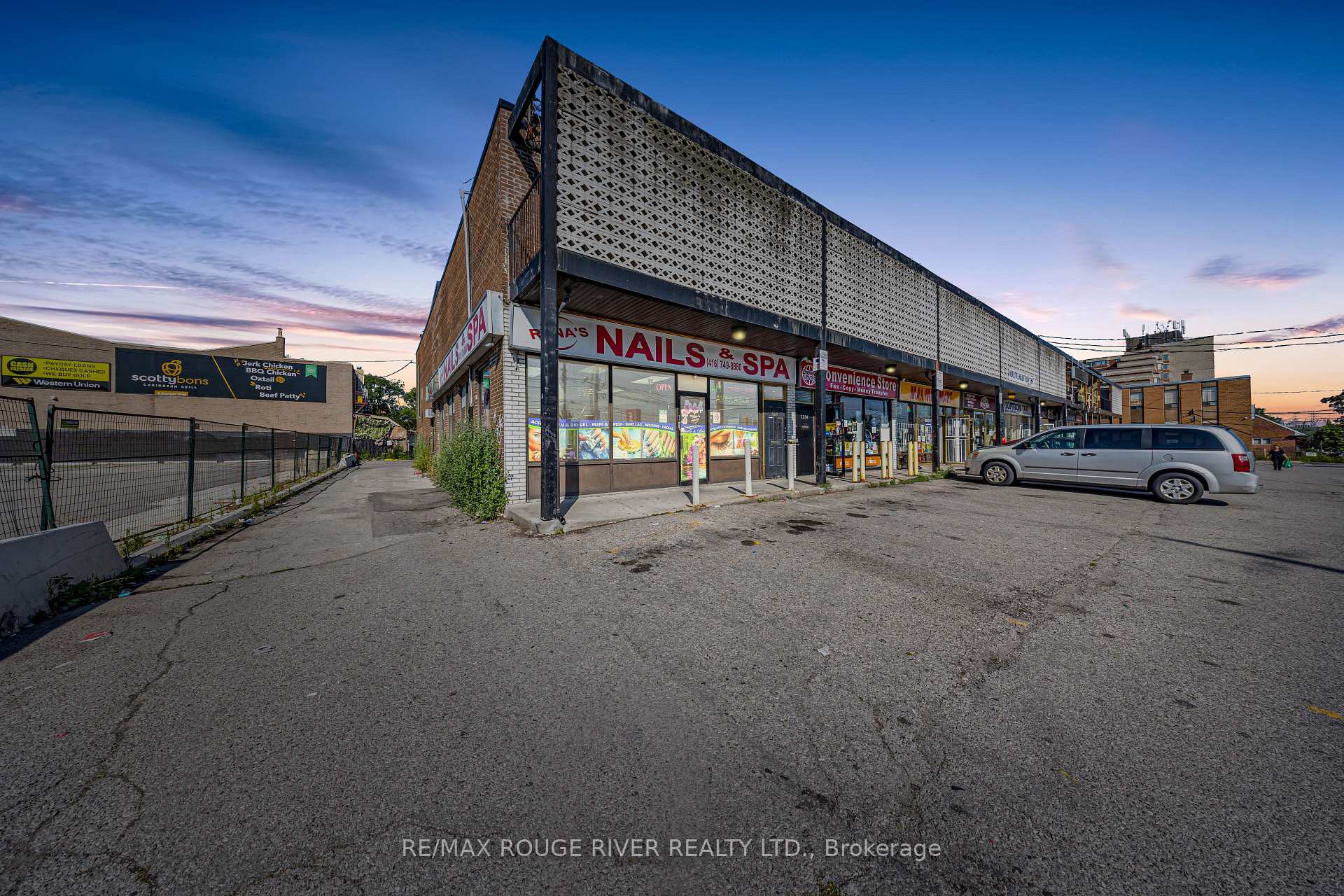 Retail plaza with nail spa and convenience store, patterned facade, and a minivan in the parking lot.