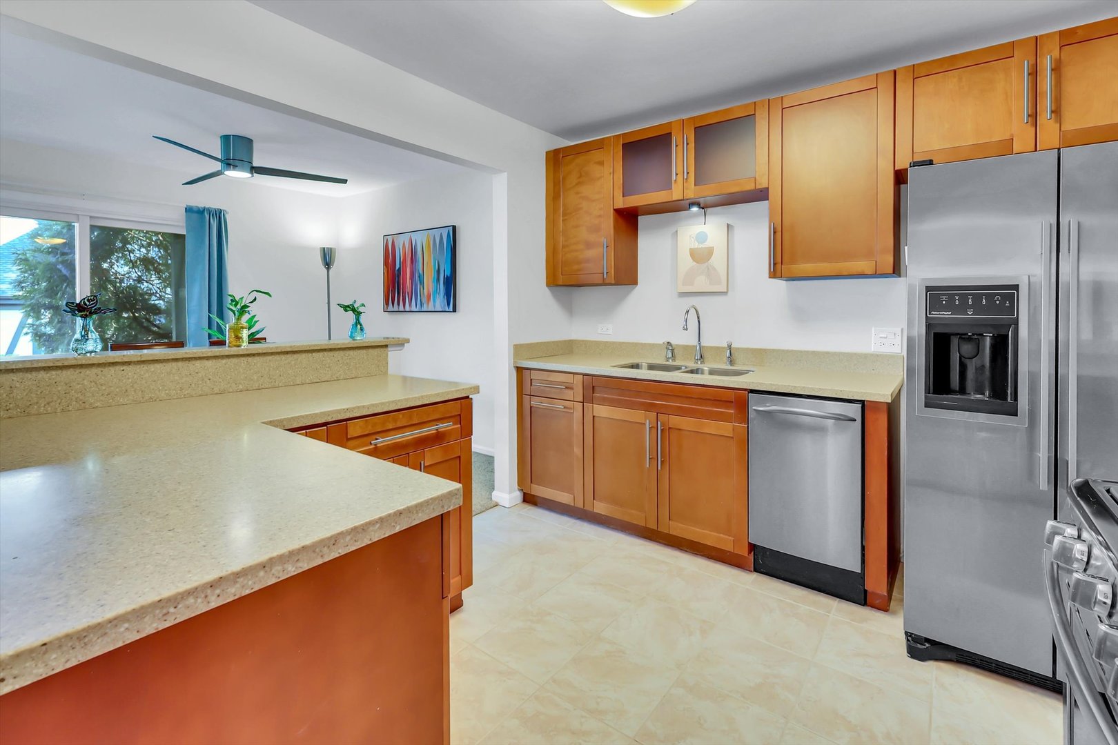 Kitchen with maple cabinets, stone counters, a breakfast bar, and stainless steel appliances.