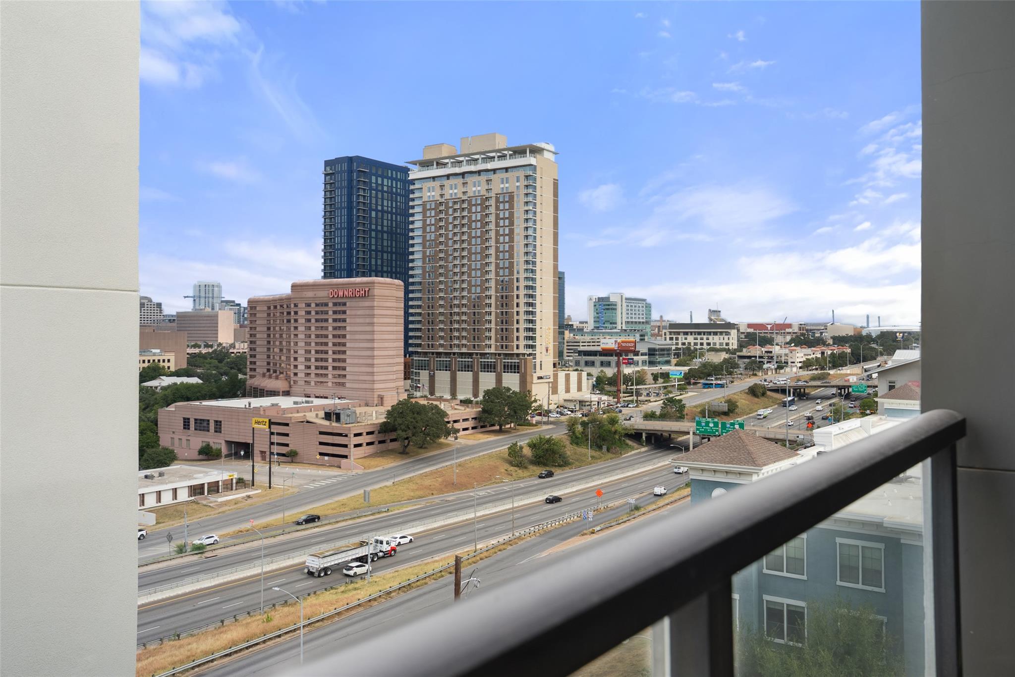 Downtown Austin view from a balcony, with the Downright hotel and highway below.