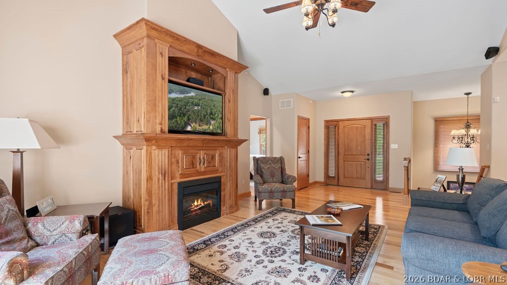 Living room with a wood built-in fireplace, patterned seating, and hardwood floors.