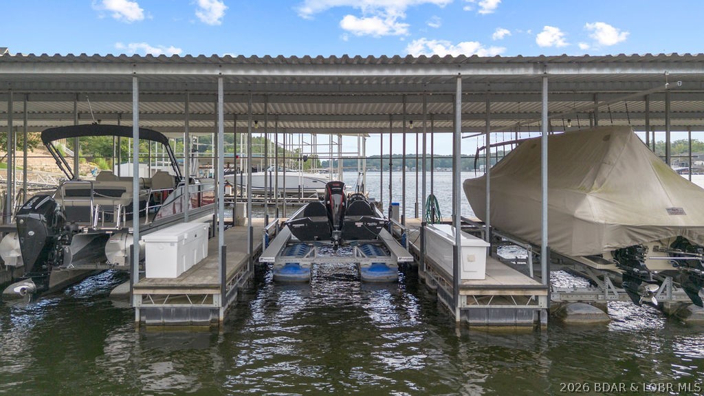 Covered boat dock with boats in slips and lake water visible beyond.