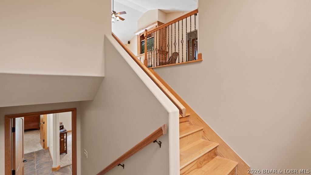 Interior staircase with wood steps, black metal balusters, and an open upper landing.