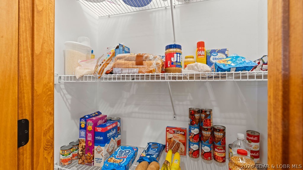 Stocked pantry with wire shelves, groceries, and canned goods.