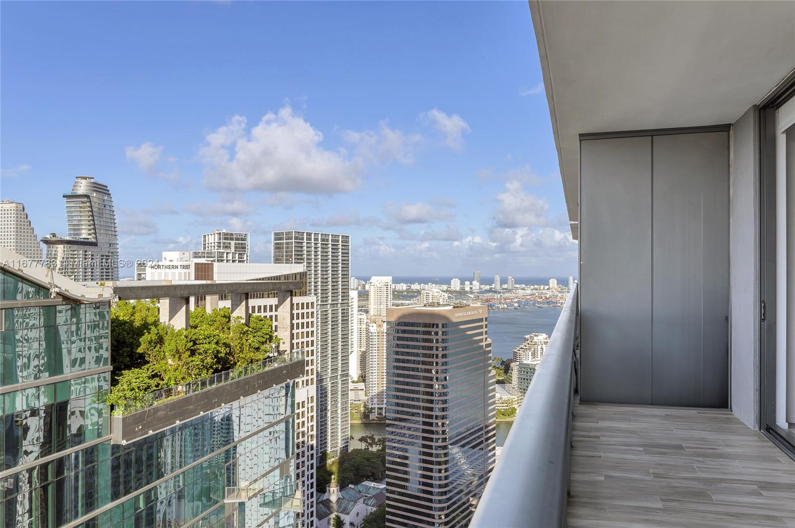 High-rise balcony overlooking downtown buildings and the bay.