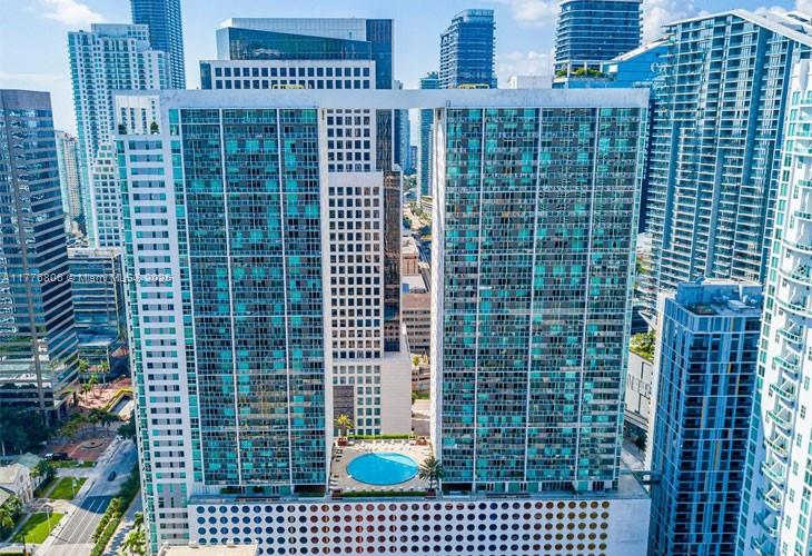 Aerial view of high-rise residential towers surrounding a rooftop pool.