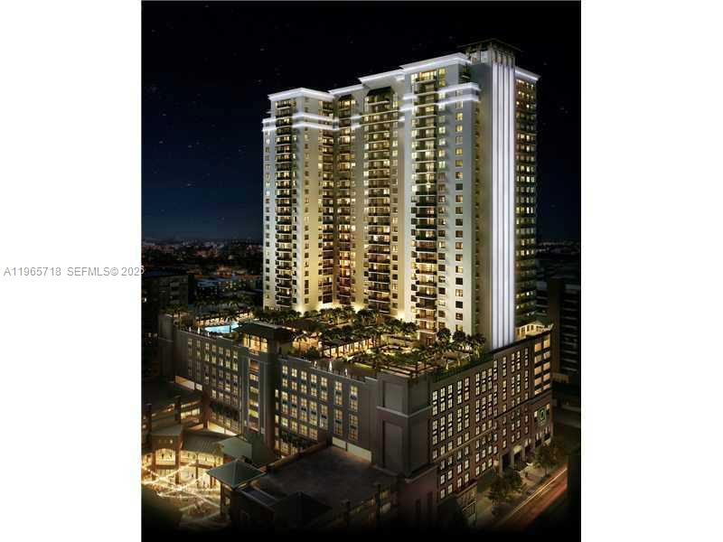 Illuminated high-rise condominium tower above a rooftop pool and landscaped terrace at night.