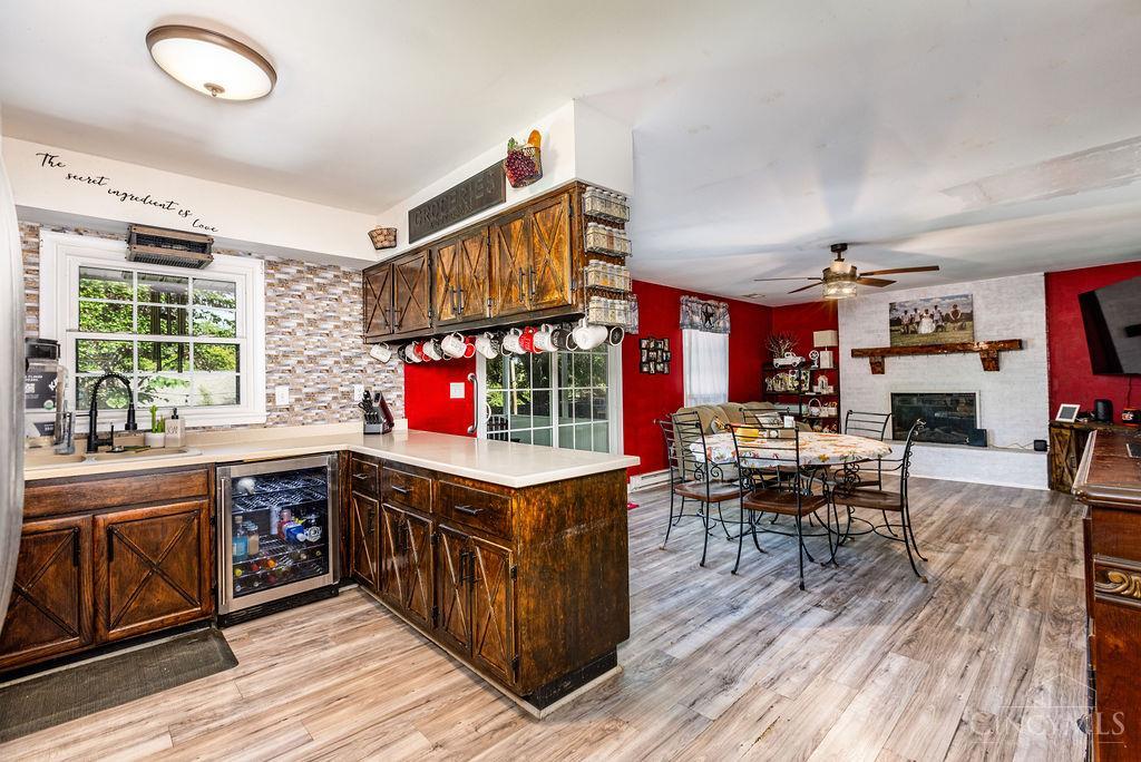 Open kitchen and dining area with rustic wood cabinets, a central island, and a fireplace.