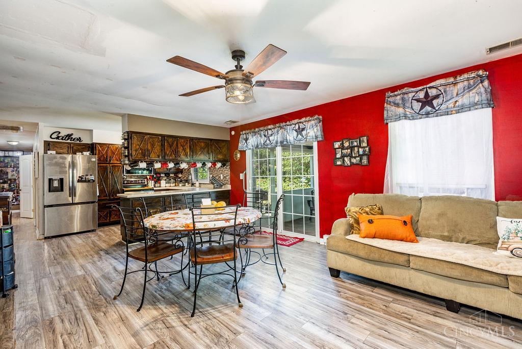 Open-plan kitchen and living room with dark wood cabinets, a red wall, and a beige sofa.