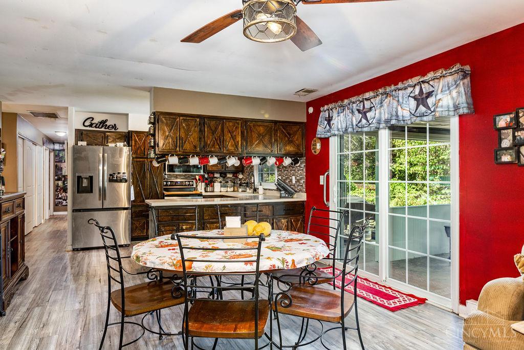 Kitchen and dining area with dark wood cabinets, a floral table, and sliding glass doors.
