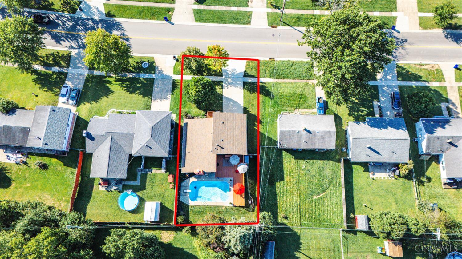 Aerial view of a home and backyard pool, with the property boundary outlined in red.
