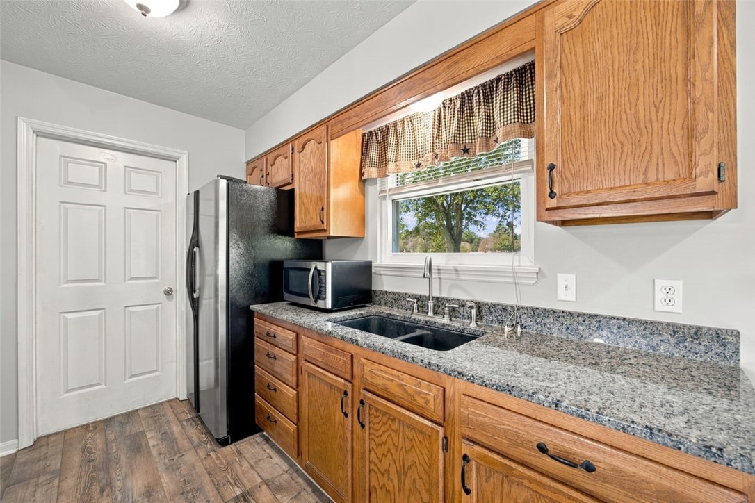 Kitchen with oak cabinets, granite counters, a double-basin sink, and stainless steel appliances.