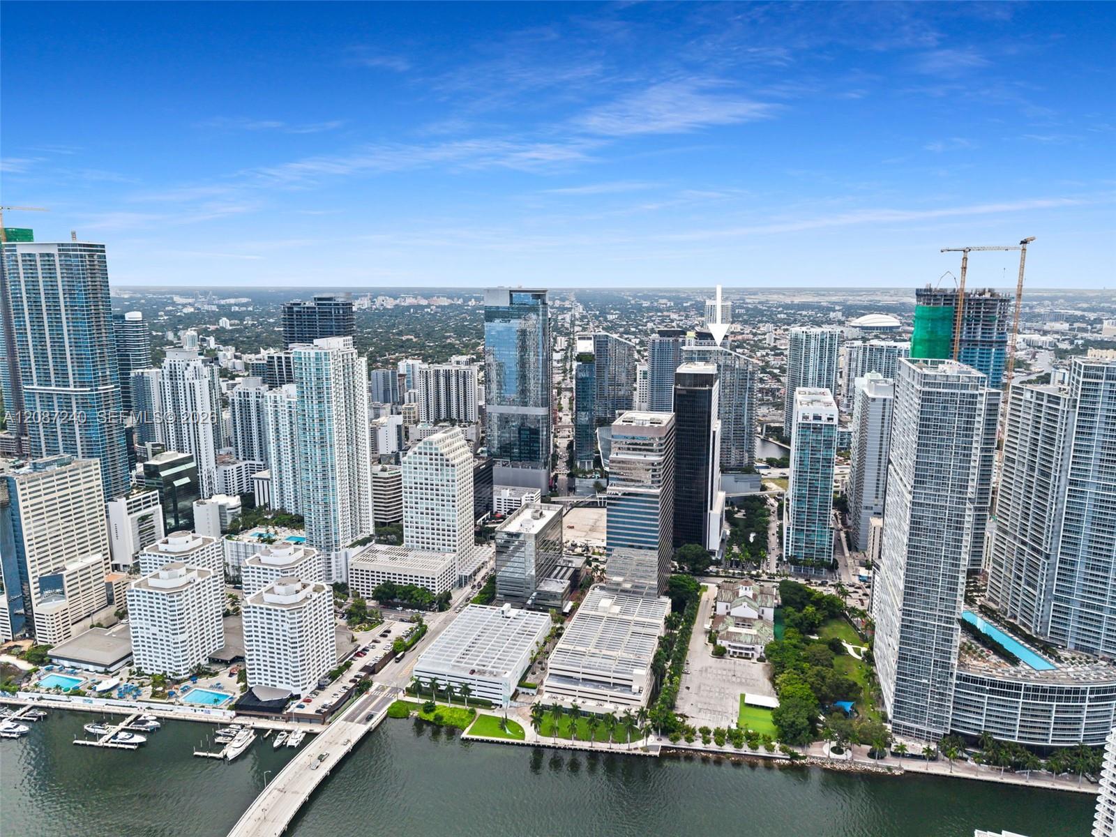 Aerial view of downtown Miami’s waterfront skyline, with an arrow pointing to a dark high-rise.