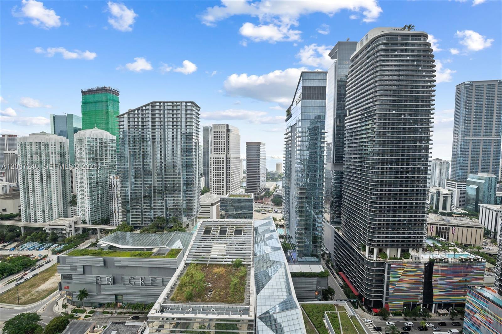 Panoramic downtown Miami skyline with high-rise towers and distant water.