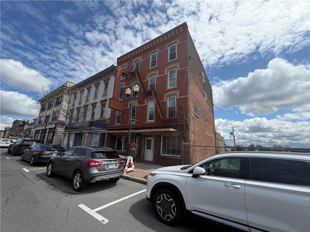 555 S Exchange Street, a red-brick commercial building with a metal fire escape on a downtown street.