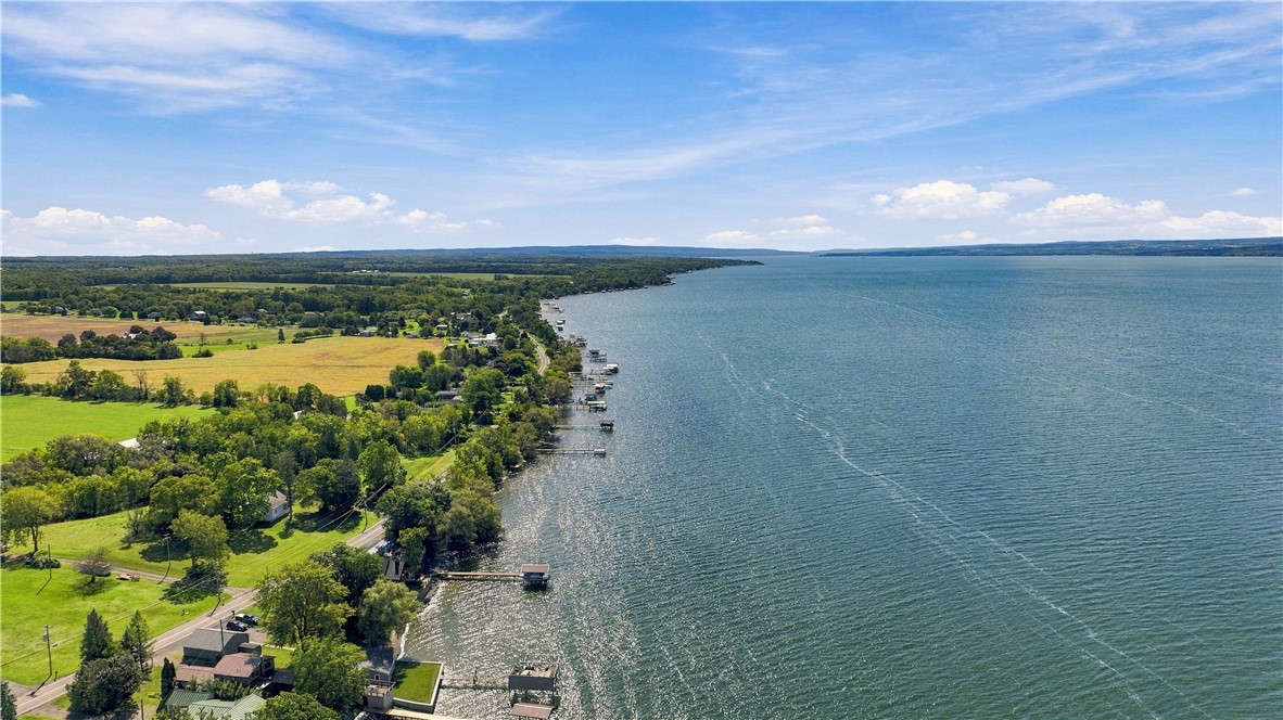 Aerial view of a lakeside property with docks, shoreline homes, and expansive blue water.