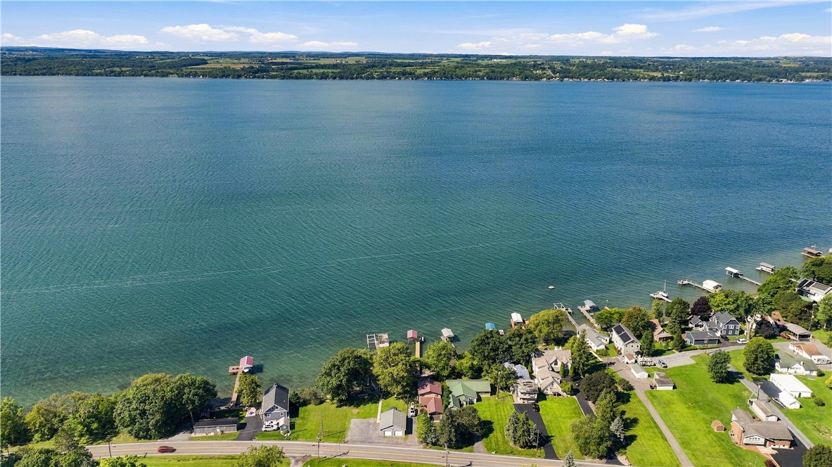 Aerial view of lakeside homes and docks along a broad blue lake.