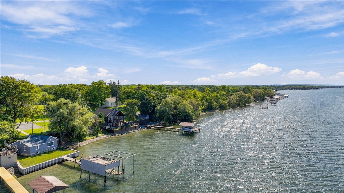 Aerial view of lakeside homes and docks along a wooded shoreline.