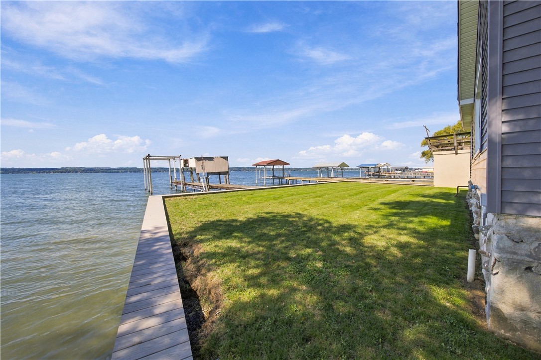Waterfront lawn beside the house, with several docks extending into the lake.