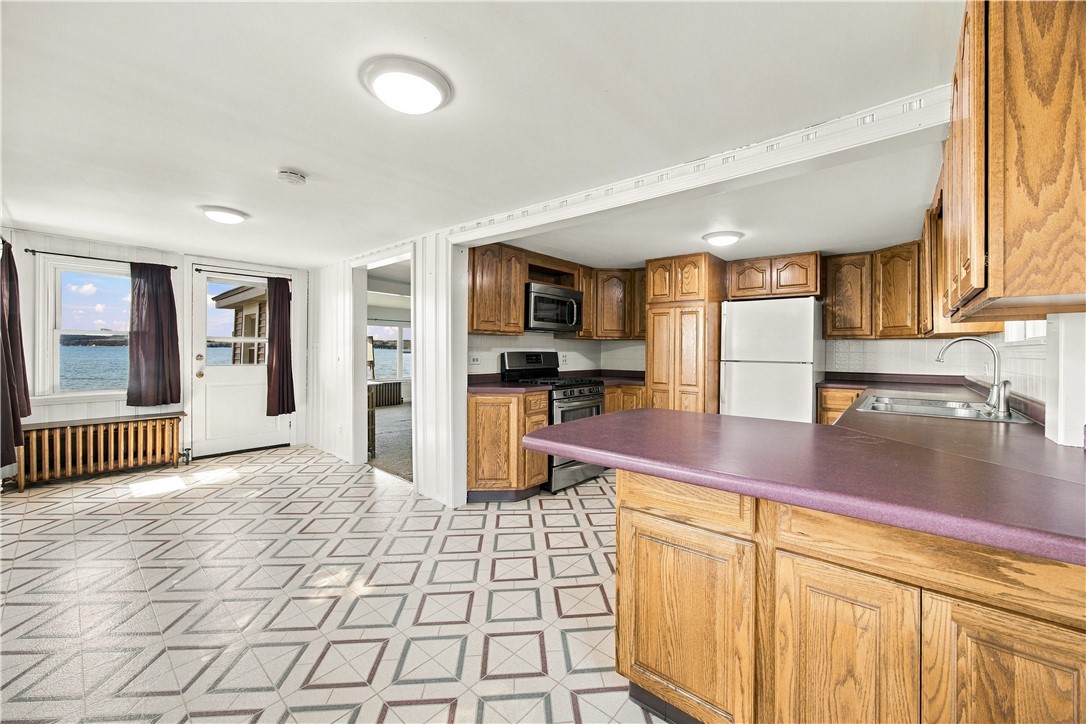 Kitchen with a purple island, oak cabinets, and lake views through the windows.