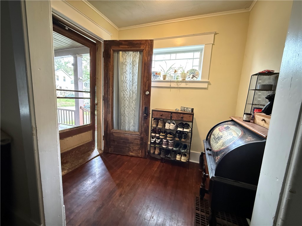 Entryway with a patterned-glass wood door, shoe rack, and dark hardwood floors.