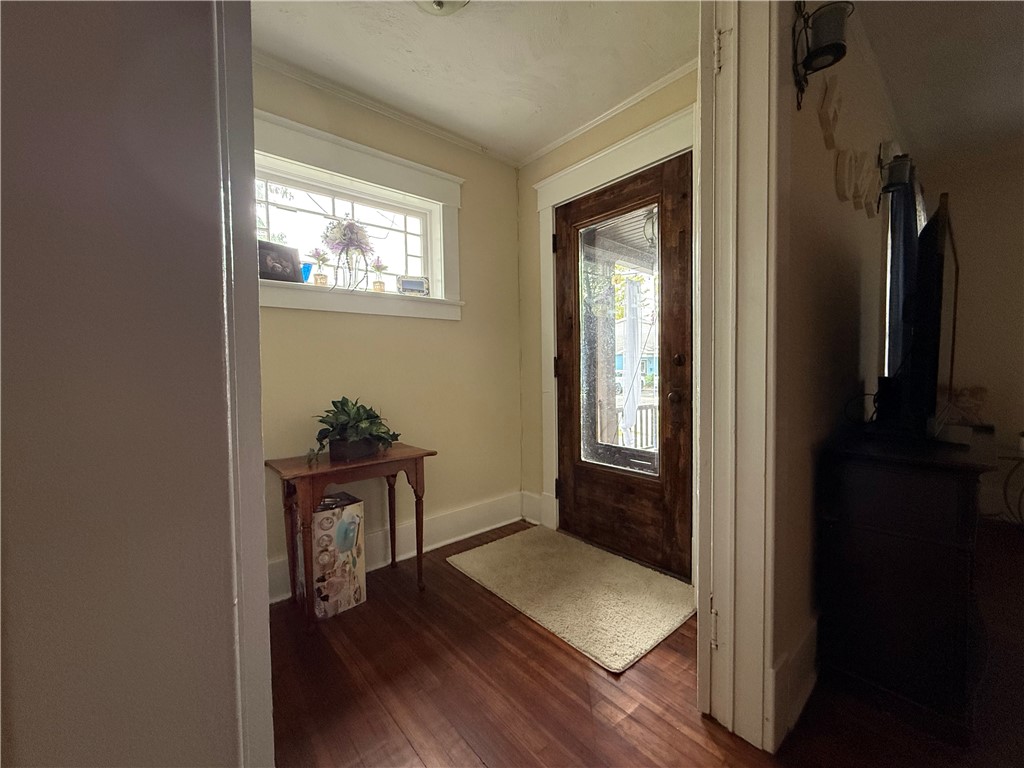 Entryway with a glass-paneled wood door, high window, hardwood floor, and console table.