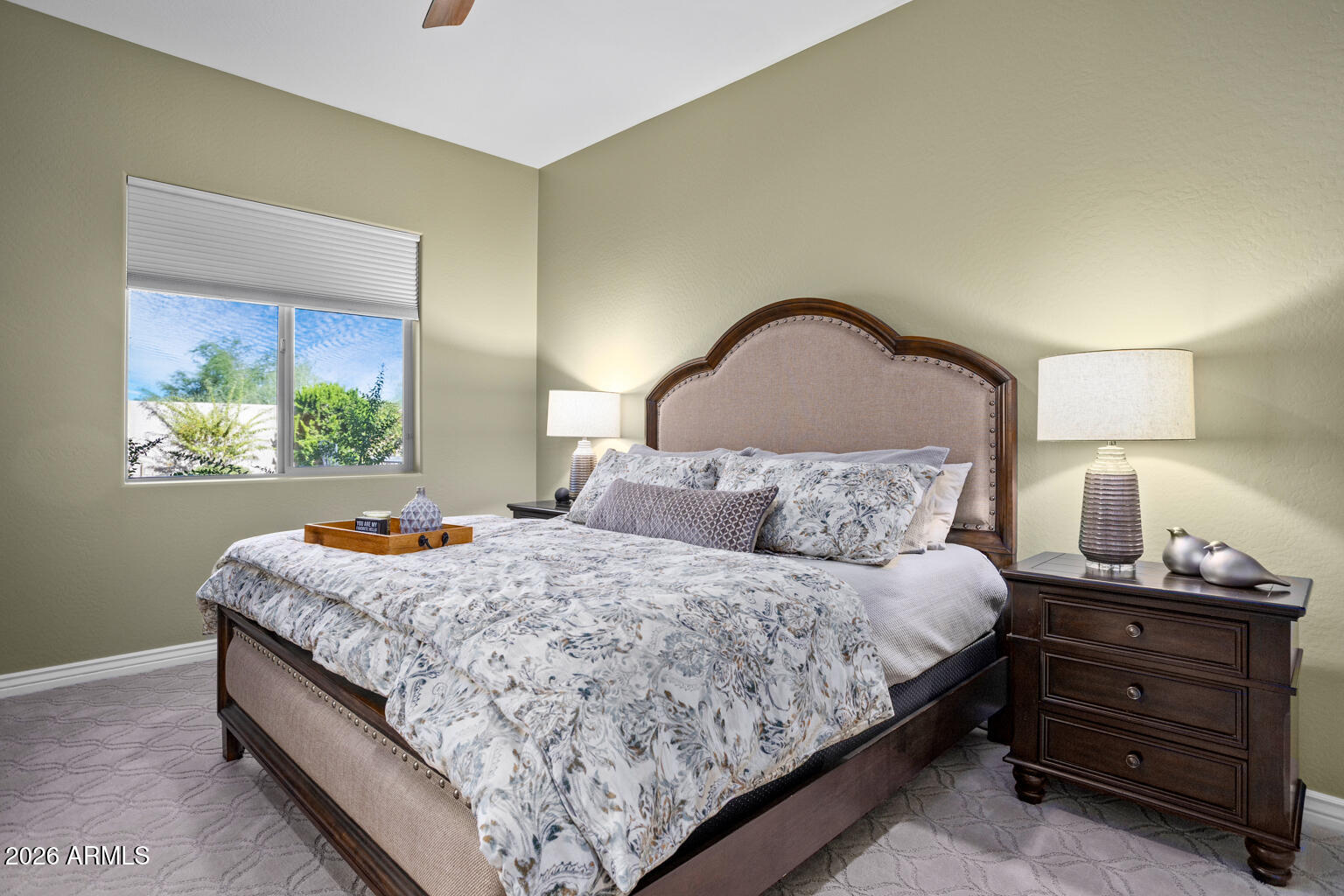 Furnished bedroom with a dark wood bed, floral bedding, matching nightstands, and a window.