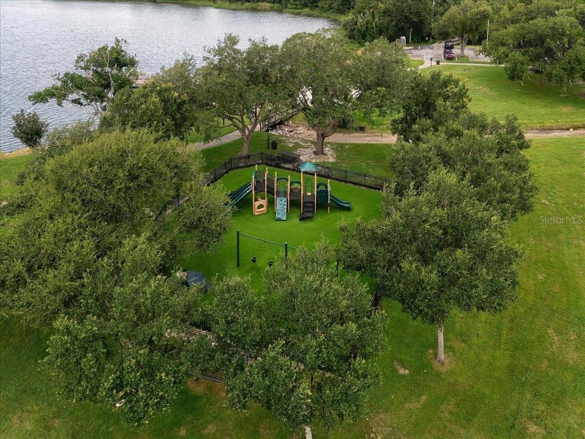 Aerial view of a tree-lined playground beside a lake.