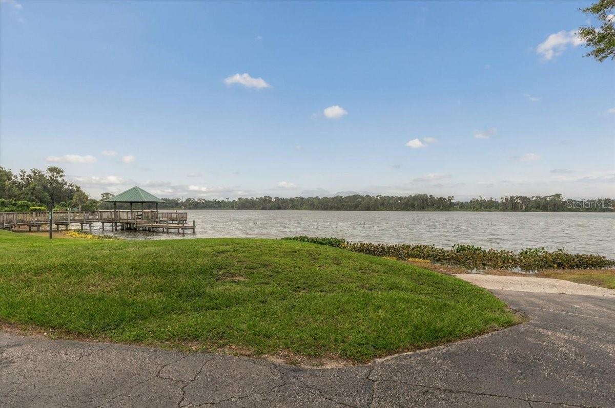 Lakeshore with a wooden dock and gazebo beside a broad lake.
