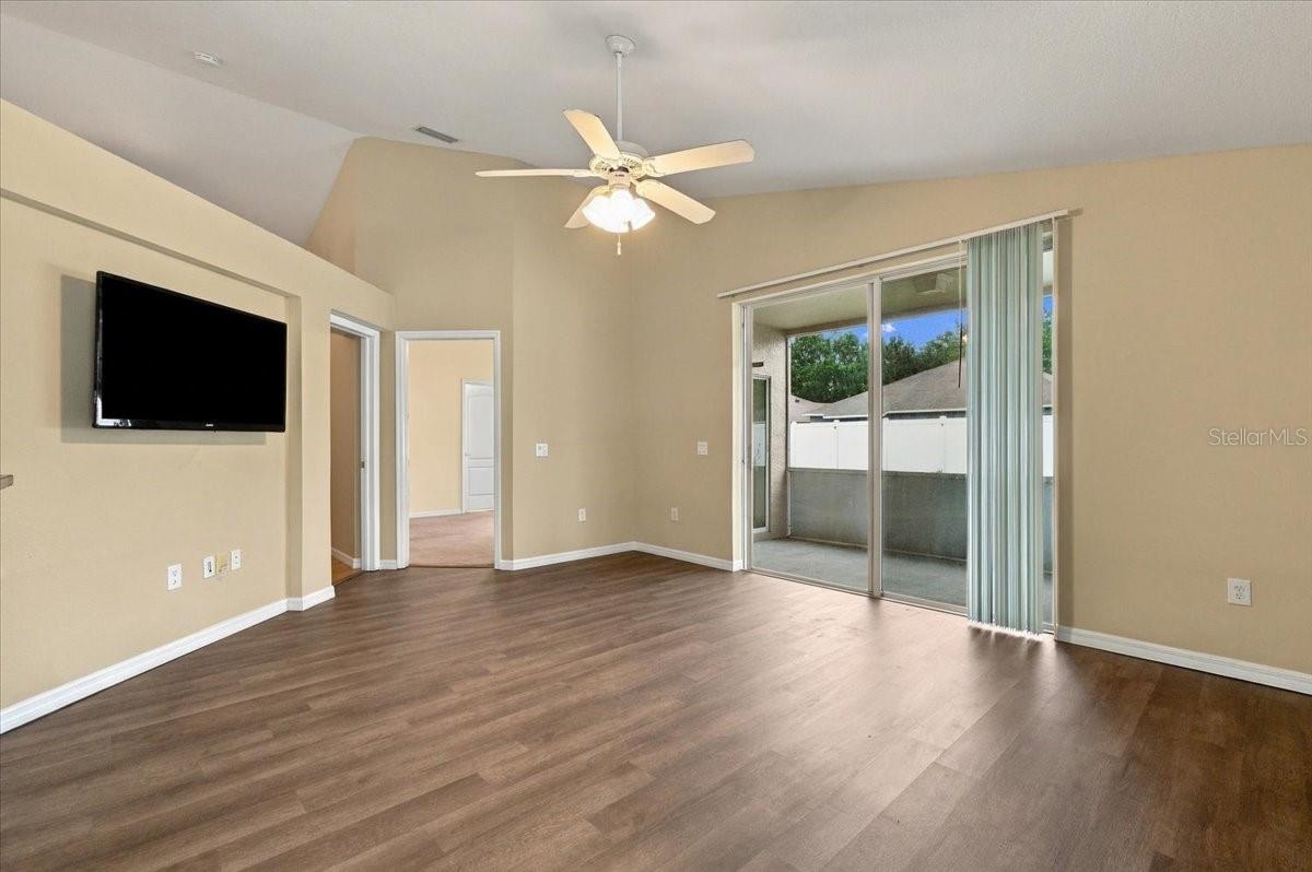 Living room with wood-look flooring, a mounted television, and sliding glass doors to a patio.