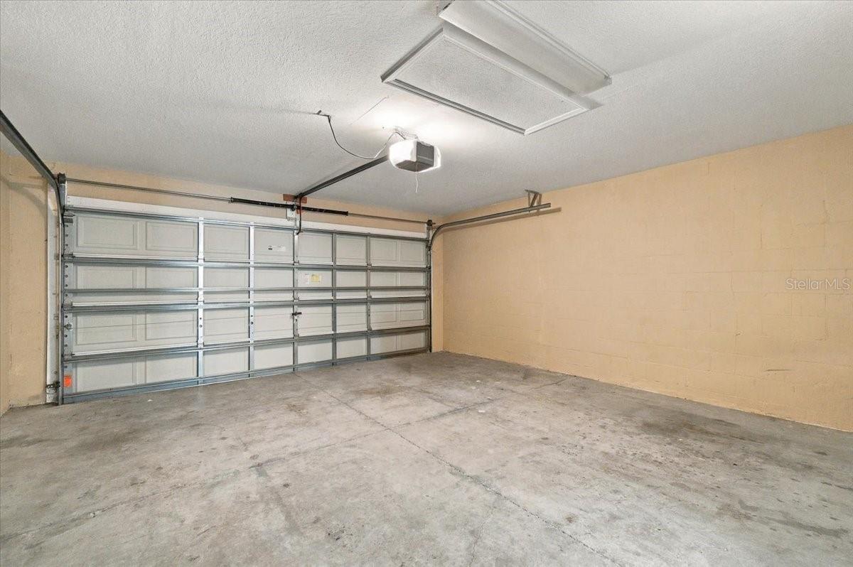 Empty garage with a concrete floor and closed sectional garage door.