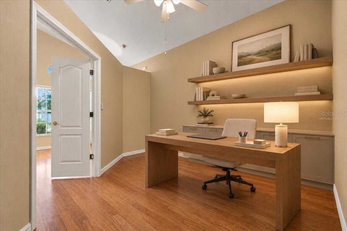 Home office with a wood desk, built-in cabinets, and illuminated floating shelves.