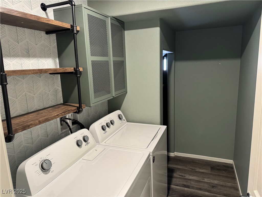 Laundry room with a washer and dryer, wood shelves, and patterned wallpaper.