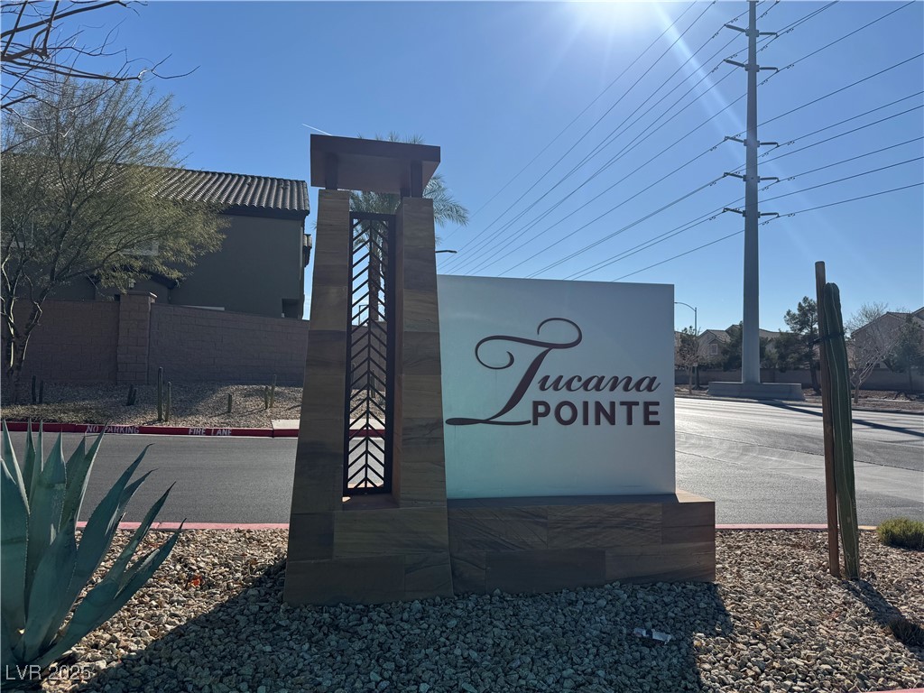 Tucana Pointe entrance sign beside a residential street, with gravel landscaping and agave plants.