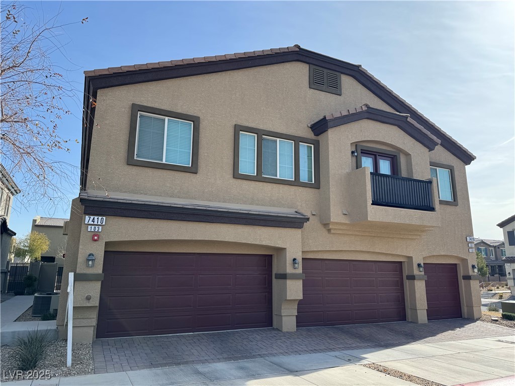 Attached two-story residence with three garage doors and an upper-level balcony.