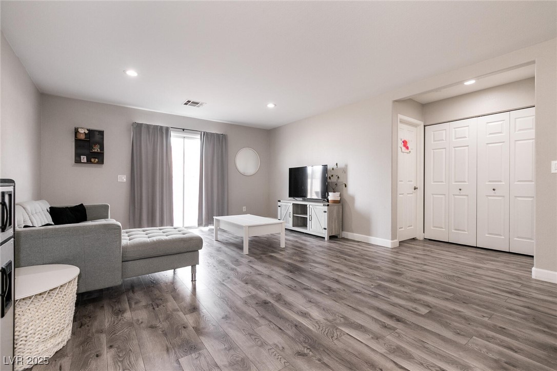 Living room with a gray sectional, white coffee table, and wide-plank gray flooring.