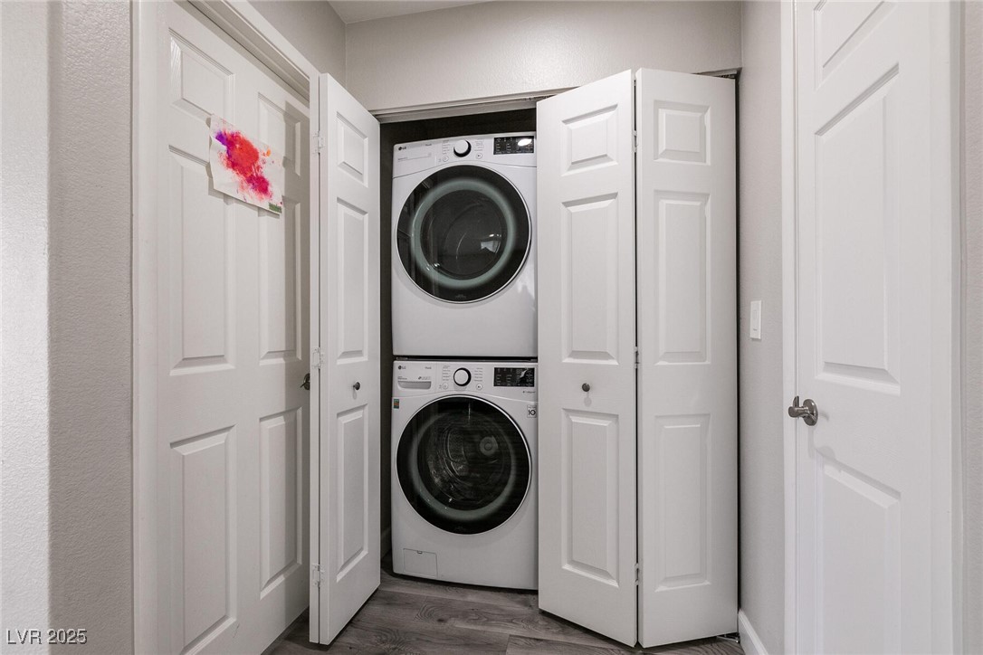 Stacked washer and dryer in a laundry closet with the bifold doors open.