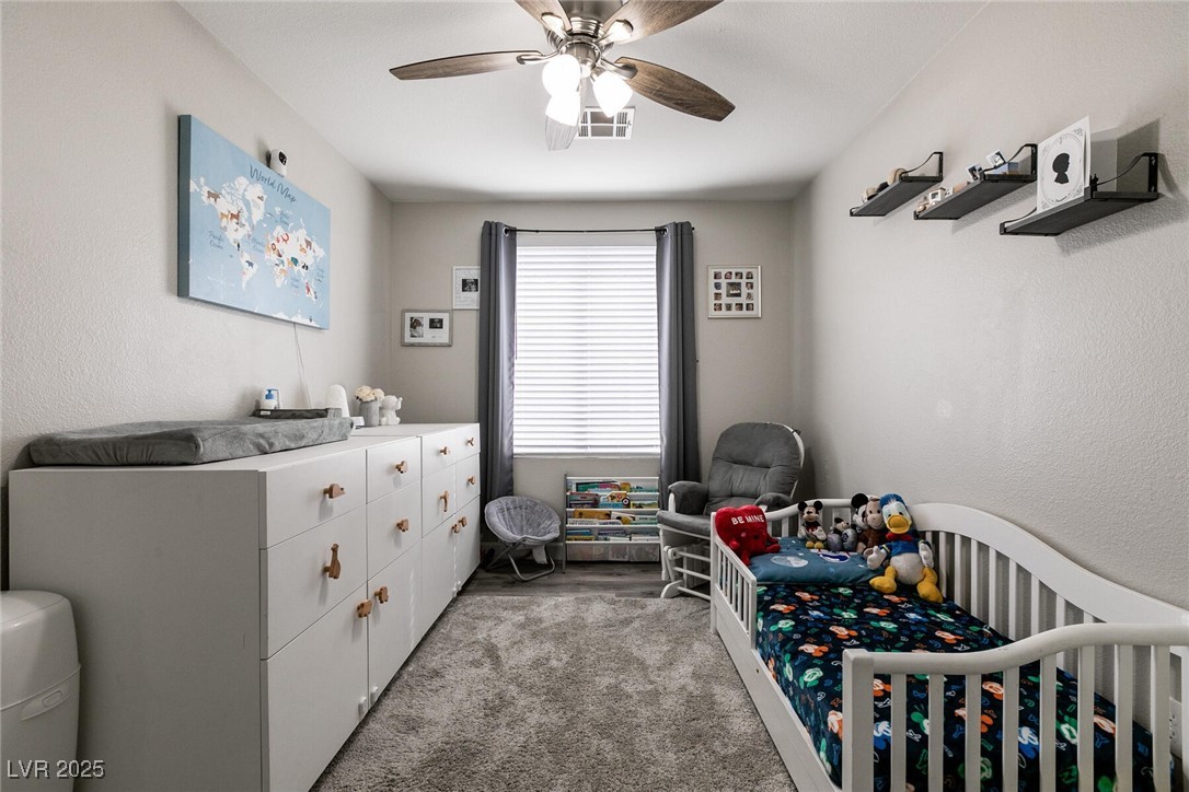 Nursery with a white crib, stuffed animals, and a long dresser beneath a world map.