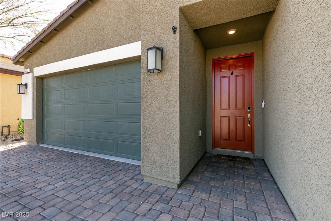 Home entrance with a recessed red front door beside a blue-gray garage door.