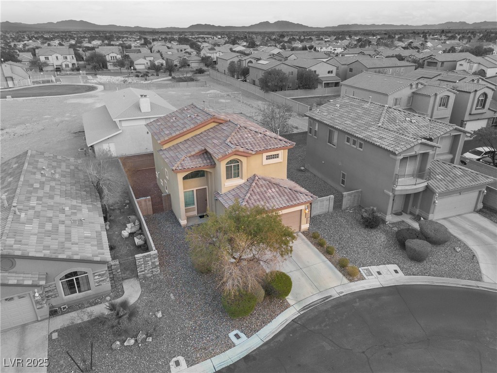Aerial view of a two-story Las Vegas home with a tile roof and desert landscaping on a cul-de-sac.