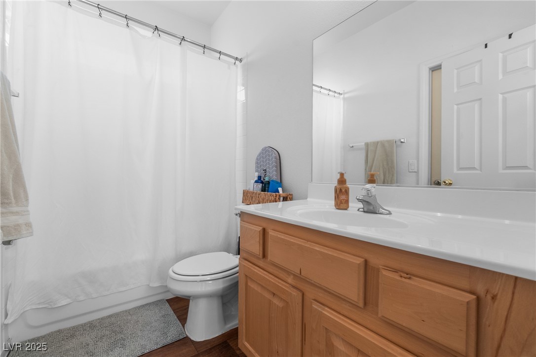 Bathroom with a wood vanity, large mirror, and white shower curtain.
