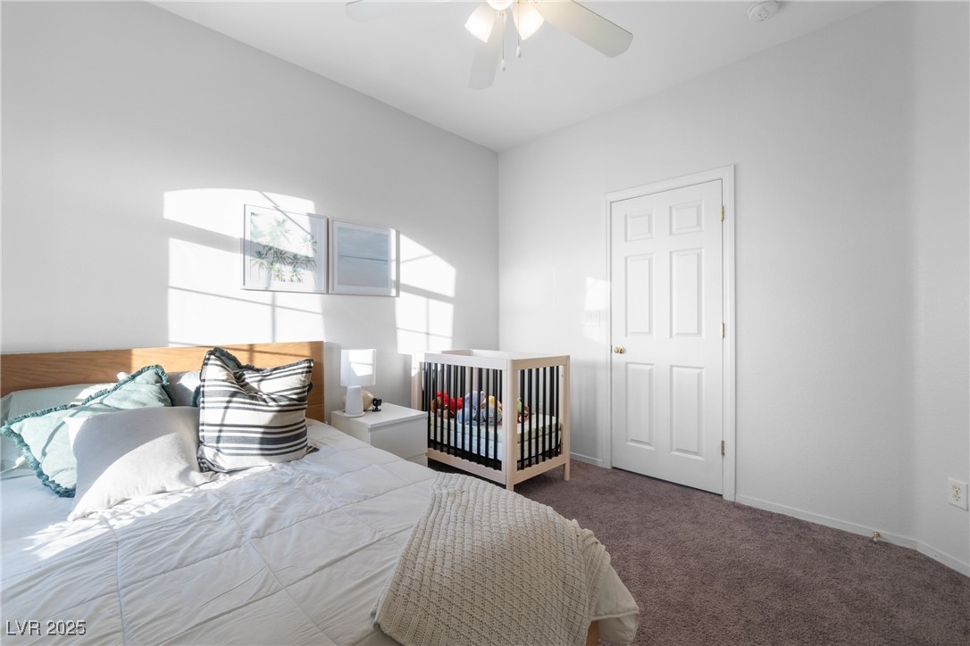 Bright bedroom with a wooden crib beside a bed and sunlight across the wall.