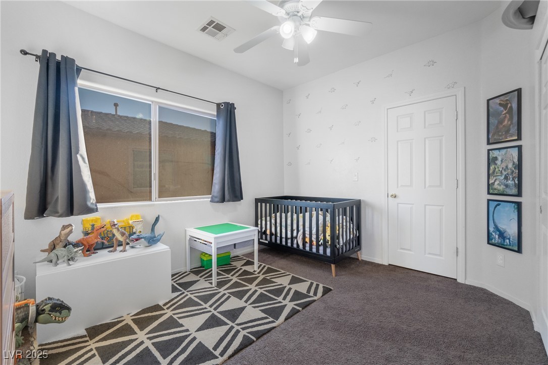 Nursery with a black crib, dinosaur toys, and a geometric rug.