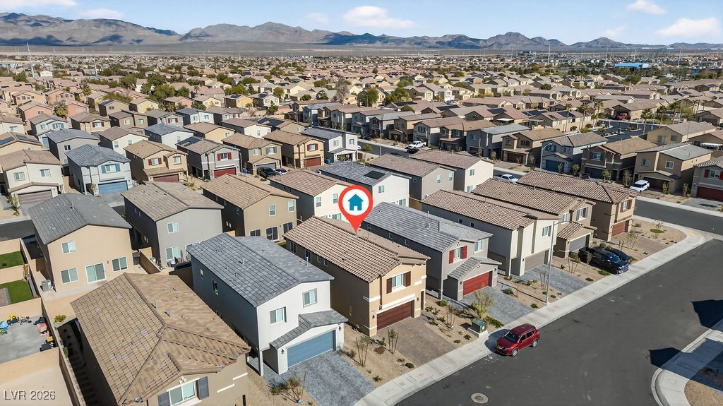 Aerial view of a home in a residential neighborhood, with mountains in the distance.