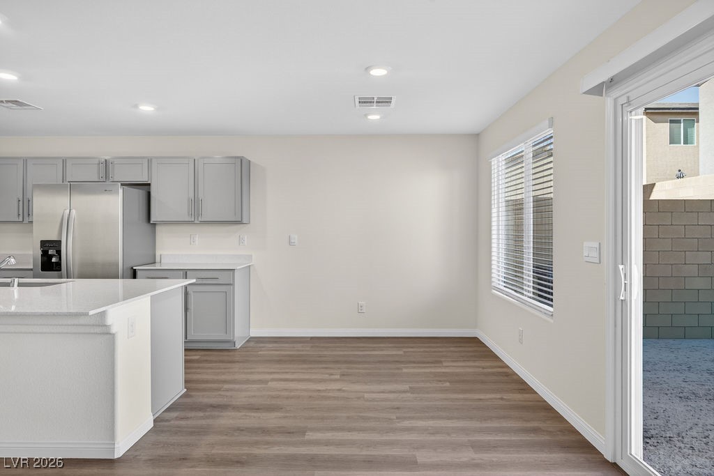 Kitchen and dining area with gray cabinets, stainless steel appliances, and an open sliding door to the patio.