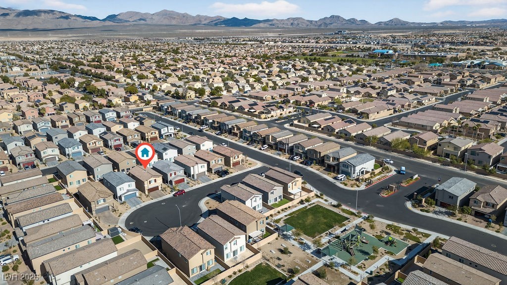 Aerial view of a North Las Vegas neighborhood, with the featured home marked and mountains in the distance.