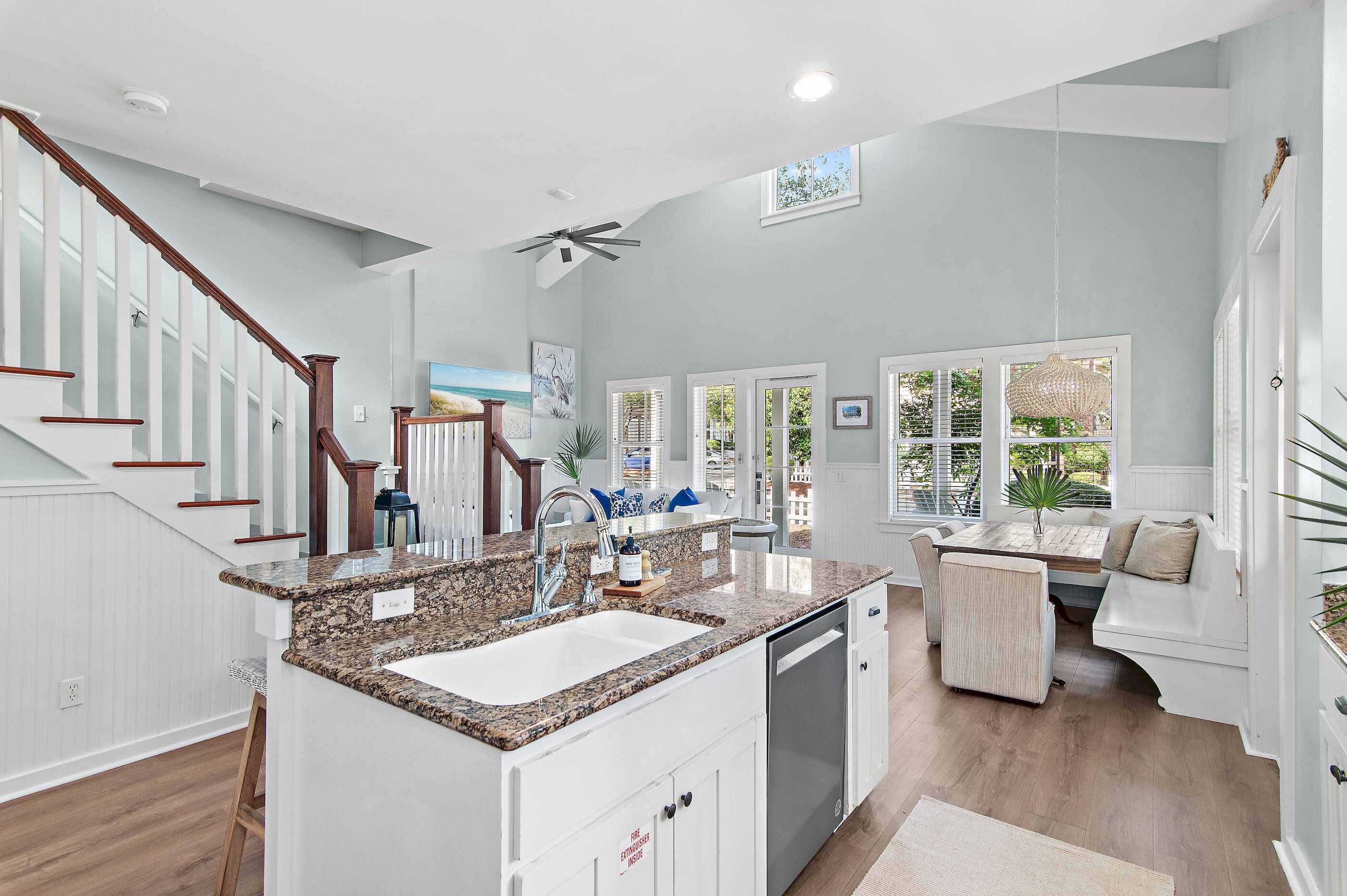 Open kitchen with granite island beside a dining nook with built-in window seating.