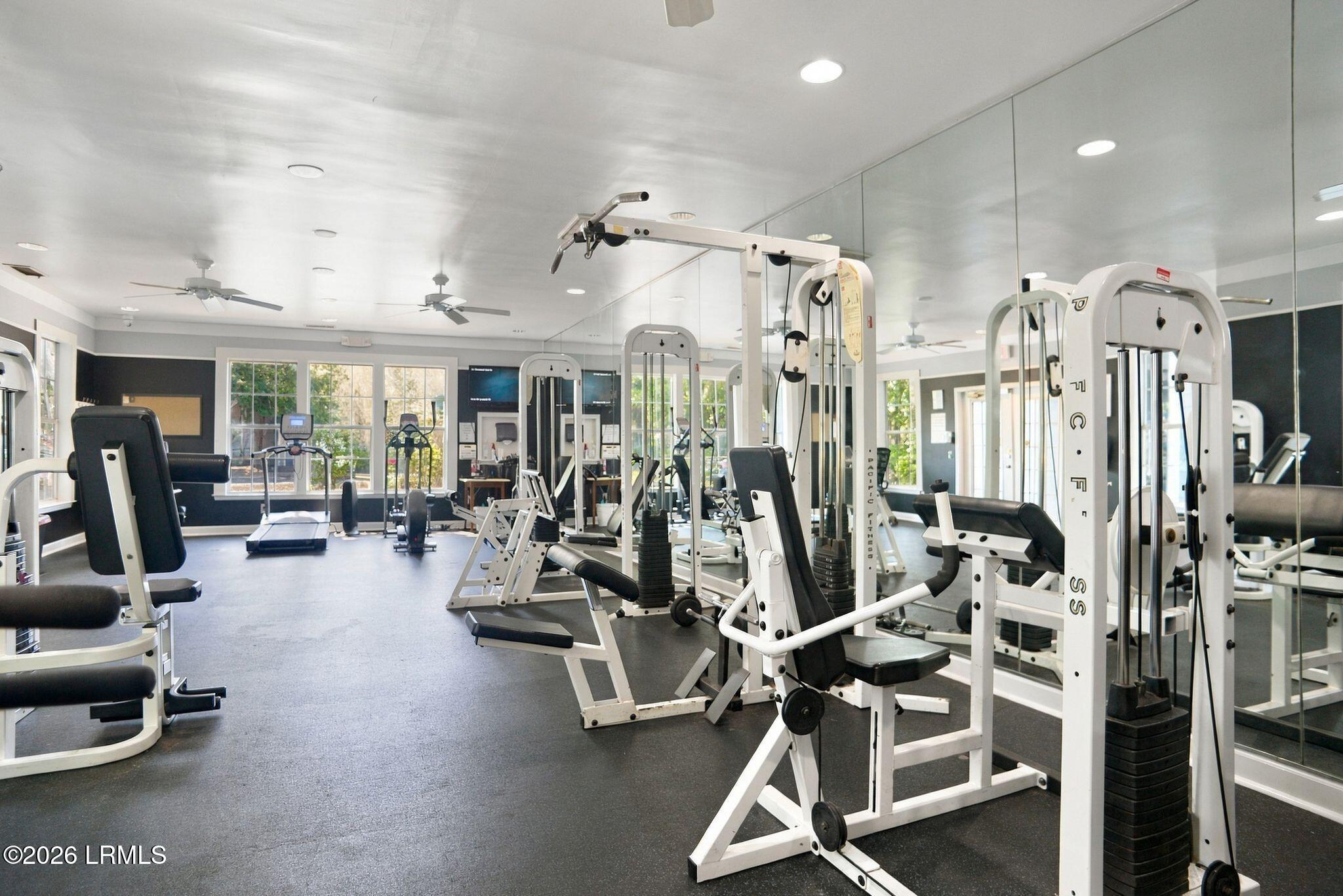 Fitness room with weight machines, mirrored walls, and large windows.
