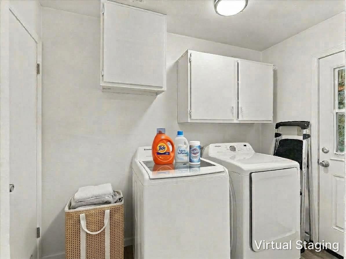 Laundry room with a top-loading washer and dryer, white cabinets, and a woven basket.