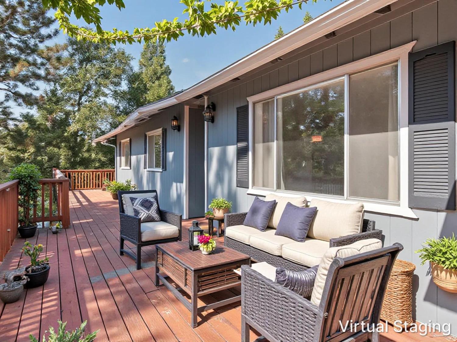 House beside a redwood deck furnished with cushioned wicker seating and surrounded by trees.